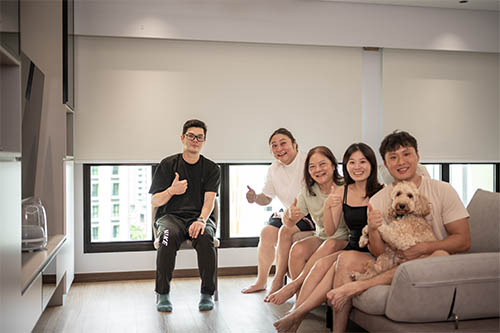 A family giving thumbs up on the sofa of their newly renovated home