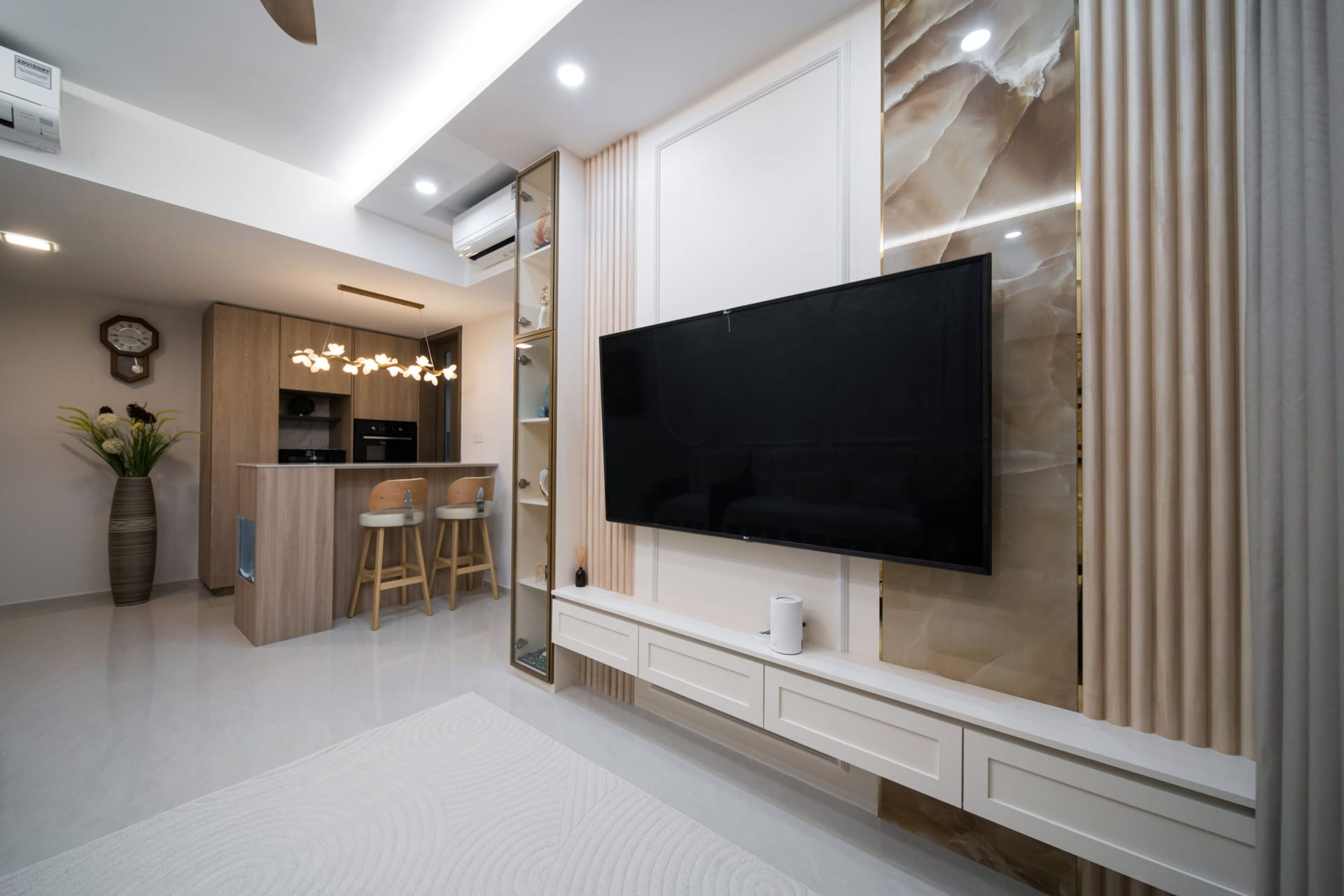 Condo living room by 82 Design Studio with fluted wall panels, an onyx-look feature wall and an oak kitchen bar